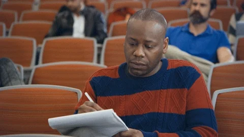 Malcolm Barrett taking notes in a scene from the TV series 'Now We're Talking'