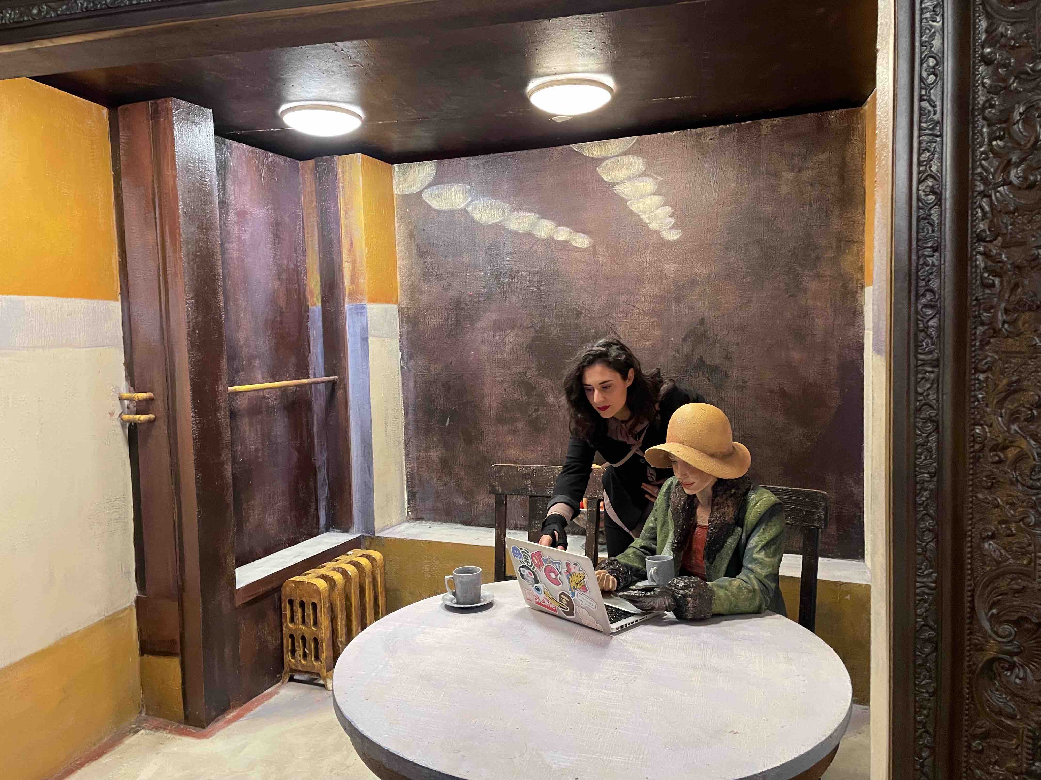 Francesca pointing at a computer used by a mannequin in a life-sized portrait