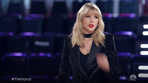 Taylor Swift sending a chef's kiss during the show 'The Voice'